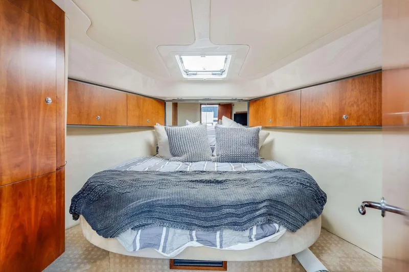 Slide: The Image of Luxurious 2007 Riviera yacht cabin with cozy bed, wooden cabinets, and skylight. - 16