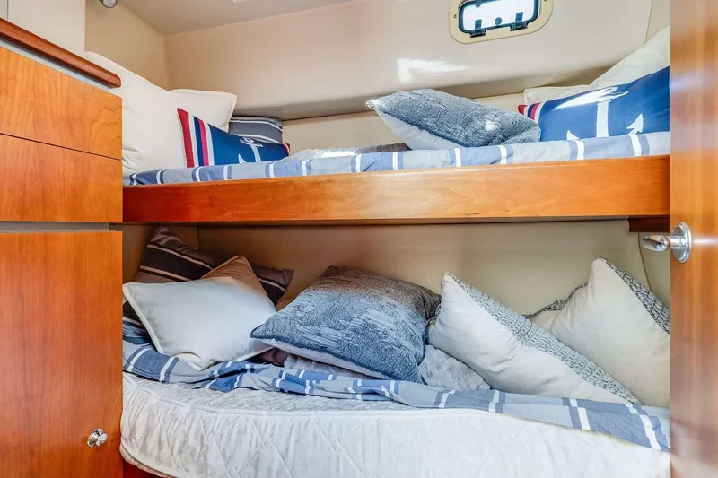 Slide: The Image of Cozy 2007 Riviera yacht cabin with bunk beds and nautical-themed pillows. - 19