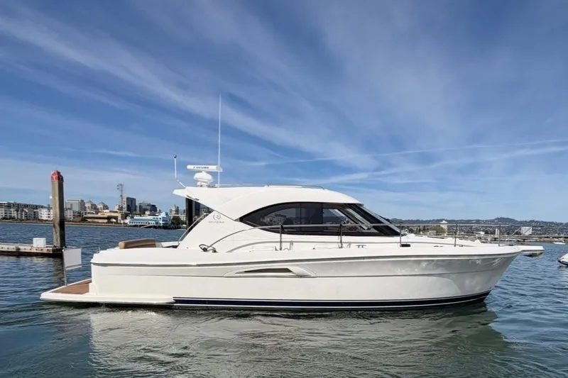 Slide: The Image of 2007 Riviera 3600 Sport Yacht on water, cityscape background, clear sky. - 2