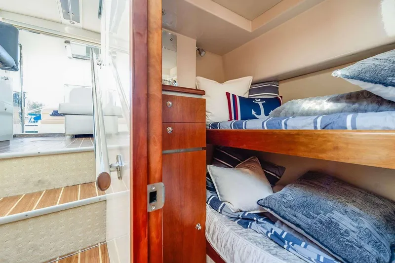 Slide: The Image of 2007 Riviera boat interior with cozy bunk beds and nautical-themed decor. - 20