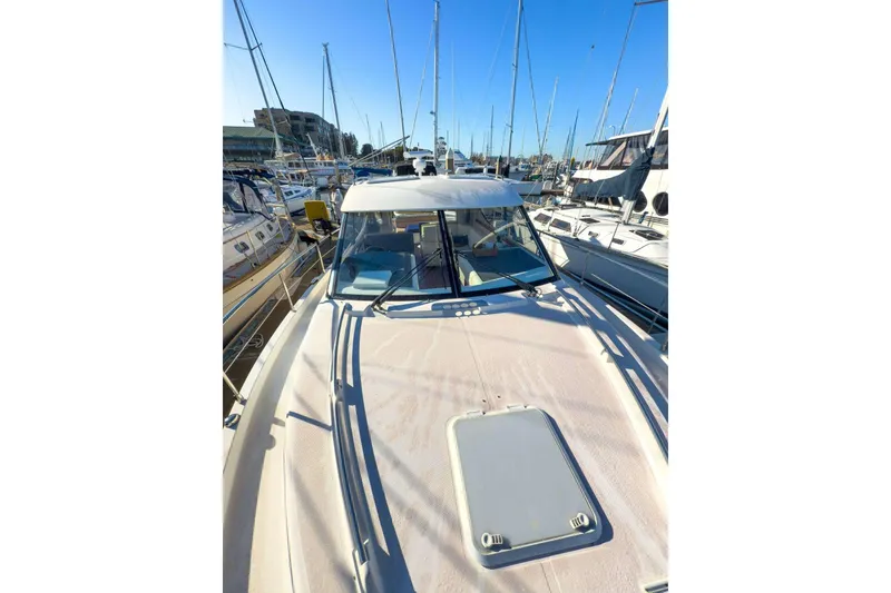 Slide: The Image of 2007 Riviera boat docked at marina, surrounded by other vessels under clear blue sky. - 23