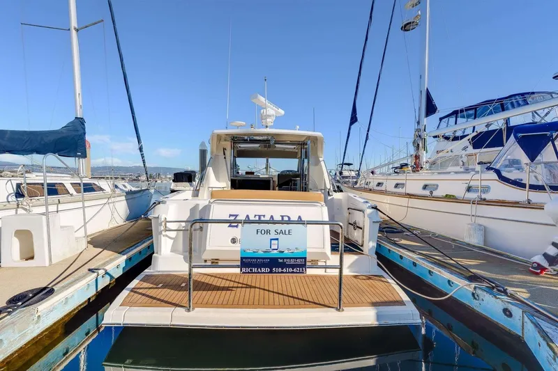 Slide: The Image of 2007 Riviera yacht "Zatara" for sale at marina dock, clear sky background. - 25