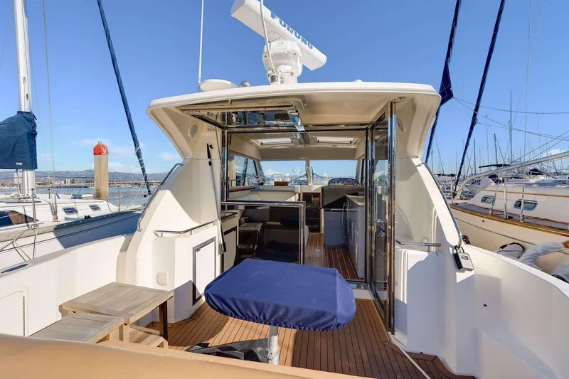 Slide: The Image of 2007 Riviera yacht interior with wooden deck, docked at marina under clear blue sky. - 3
