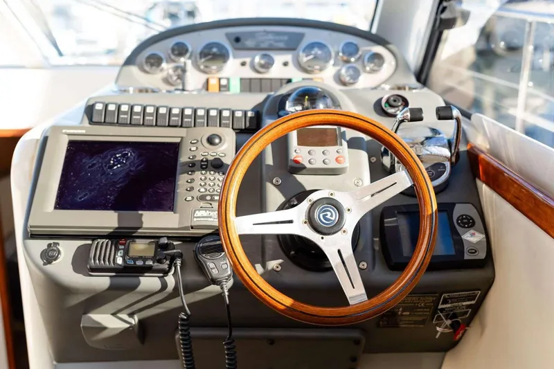 Slide: The Image of 2007 Riviera boat dashboard with wooden steering wheel and navigation controls. - 7