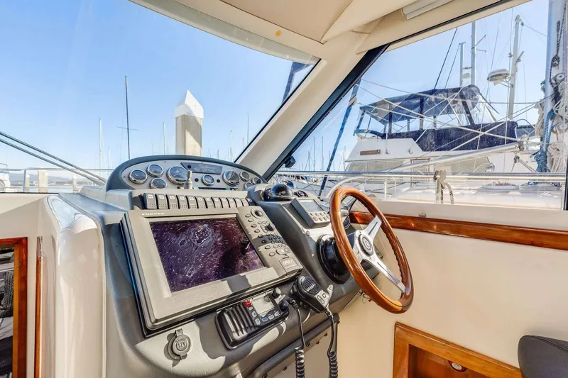 Slide: The Image of 2007 Riviera boat cockpit with navigation equipment and wooden steering wheel. - 9