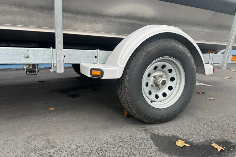 Slide: The Image of Trailer wheel of 2022 Duckworth 18 Advantage Sport boat on pavement with fallen leaves. - 2