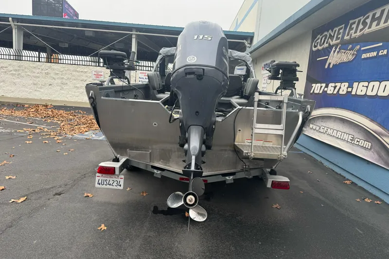 Slide: The Image of 2022 Duckworth 18 Advantage Sport boat with outboard motor, parked near a marine shop. - 8