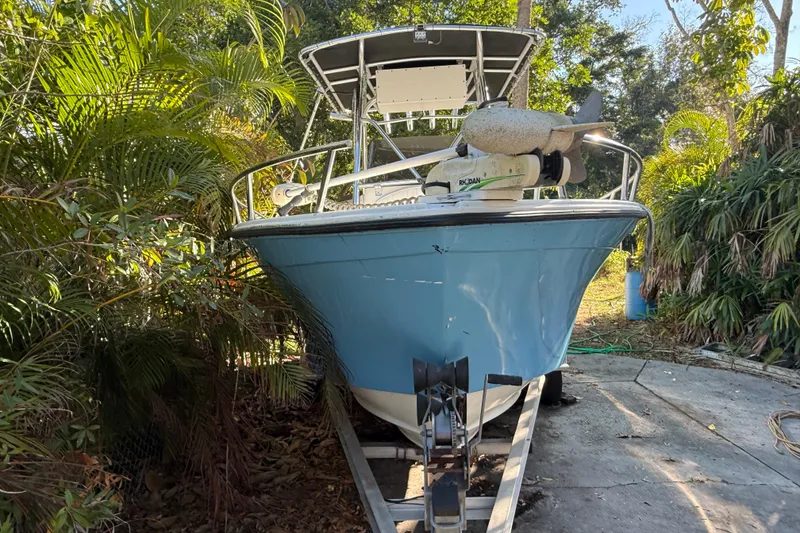 Slide: The Image of 2002 Fishmaster 212 Travis Edition boat on trailer, surrounded by lush greenery. - 3