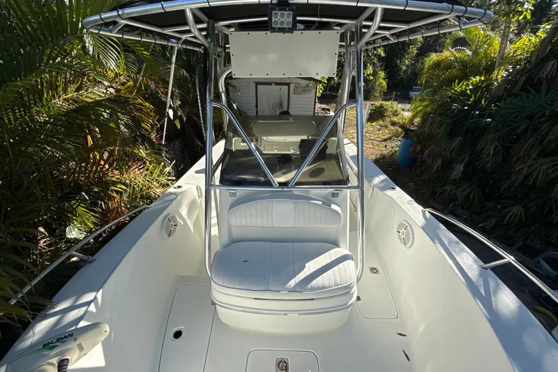 Slide: The Image of 2002 Fishmaster 212 Travis Edition boat with seating, surrounded by lush greenery. - 30