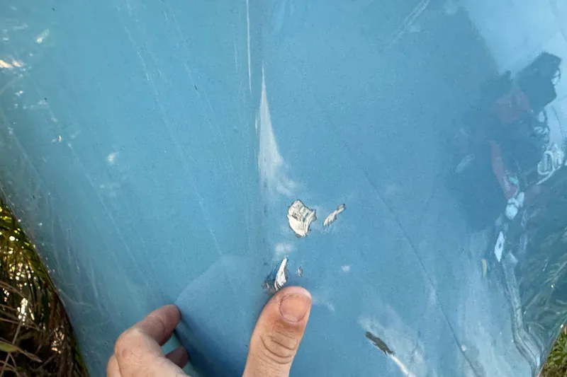 Slide: The Image of Close-up of damage on blue 2002 Fishmaster 212 Travis Edition boat hull. - 39