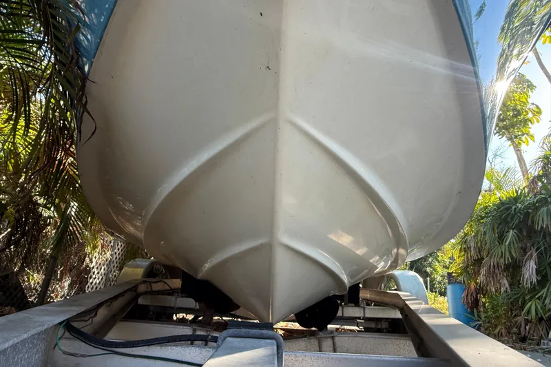 Slide: The Image of 2002 Fishmaster 212 Travis Edition boat on trailer, surrounded by tropical foliage. - 4