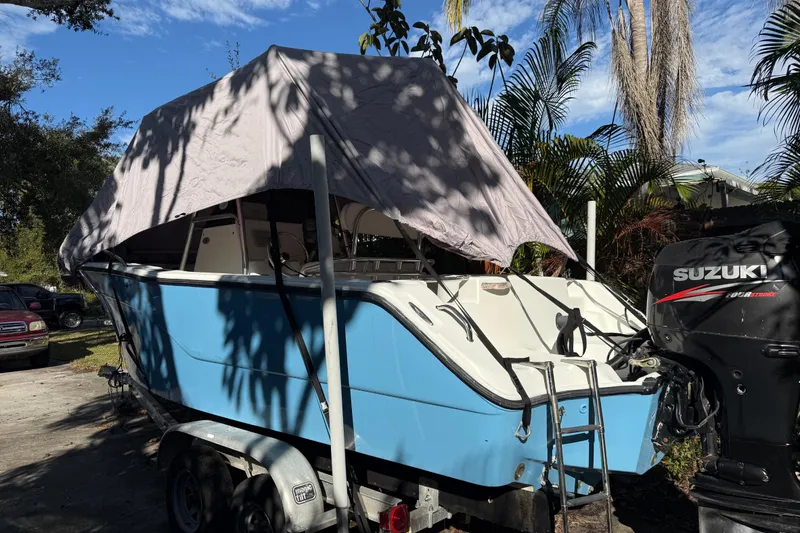 Slide: The Image of 2002 Fishmaster 212 Travis Edition boat with Suzuki outboard motor, parked on trailer. - 7