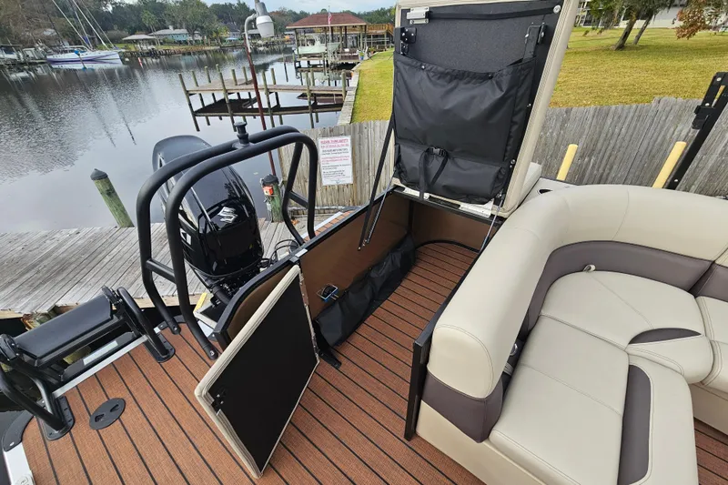 Slide: The Image of 2026 Bentley Pontoons Legacy 243 Cruise interior with seating and storage, docked by a serene lake. - 21