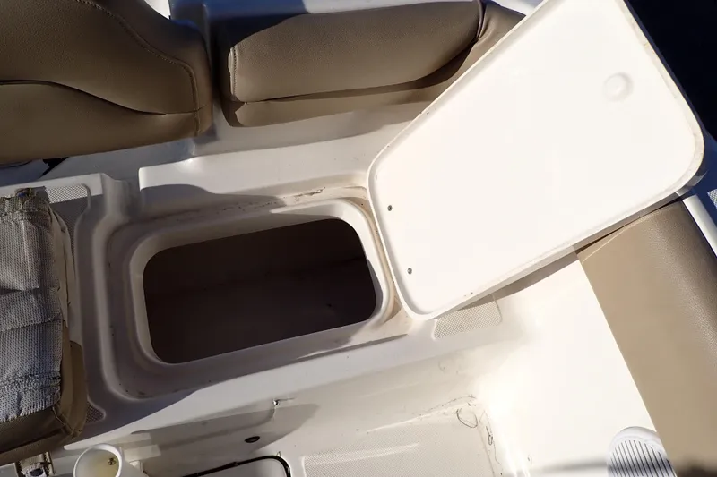 Slide: The Image of Open storage compartment on 2015 Pioneer 222 Venture boat with beige seating. - 29