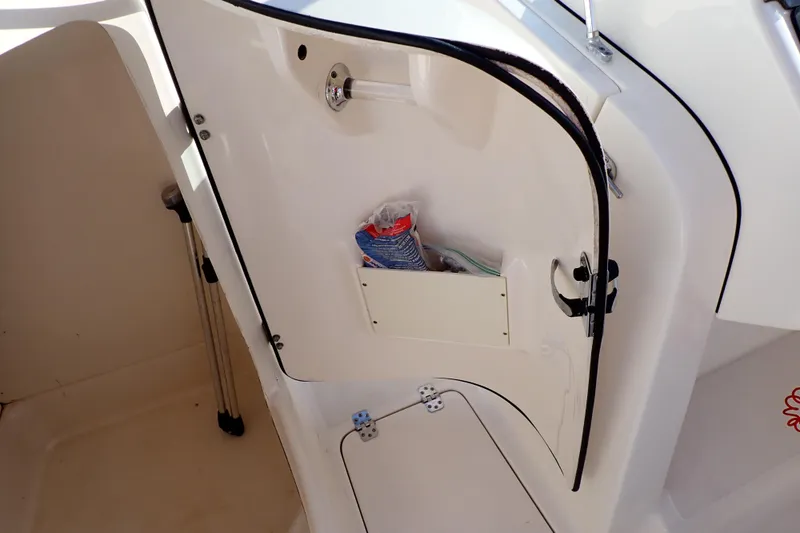 Slide: The Image of 2015 Pioneer 222 Venture boat interior storage compartment with door open. - 44