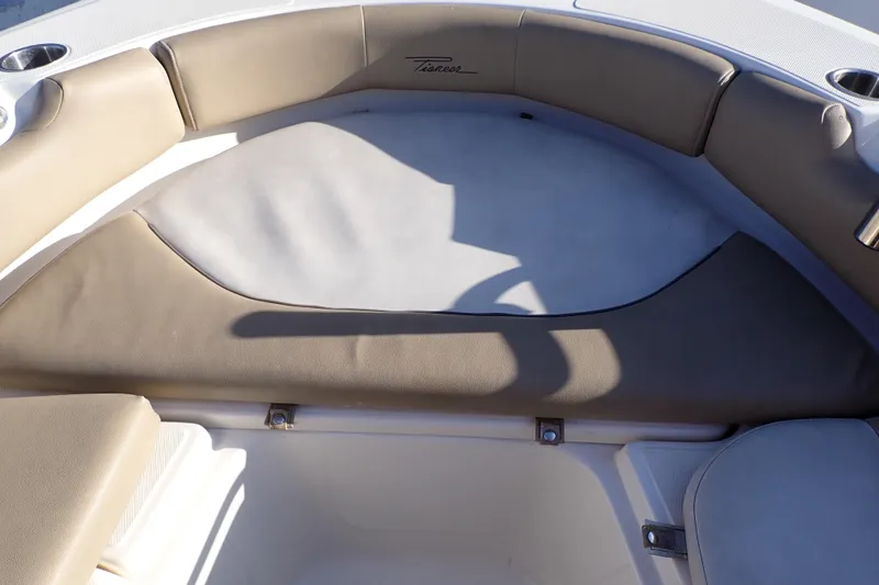 Slide: The Image of Interior seating of a 2015 Pioneer 222 Venture boat, featuring beige cushions. - 48