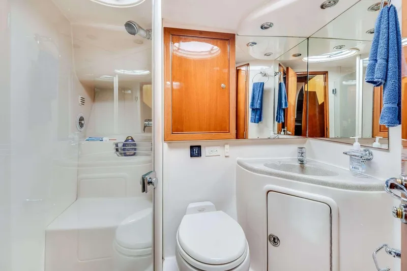 Slide: The Image of Luxurious 2004 Riviera Convertible yacht bathroom with shower, sink, and wooden cabinetry. - 10