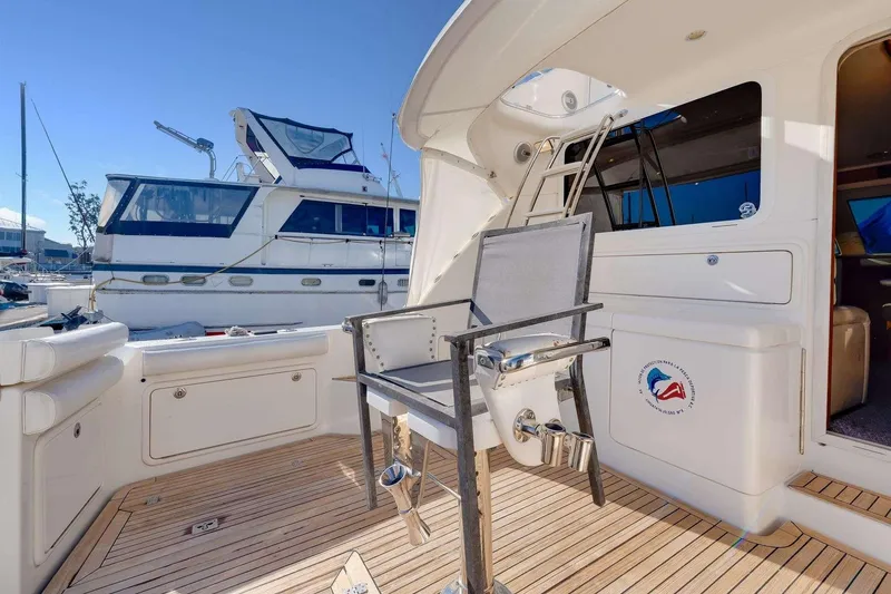 Slide: The Image of 2004 Riviera Convertible yacht deck with fishing chair and marina view. - 13