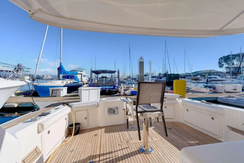 Slide: The Image of 2004 Riviera Convertible yacht deck with marina view, featuring seating and fishing equipment. - 14