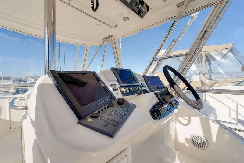 Slide: The Image of 2004 Riviera Convertible yacht helm with advanced navigation systems and steering wheel. - 15