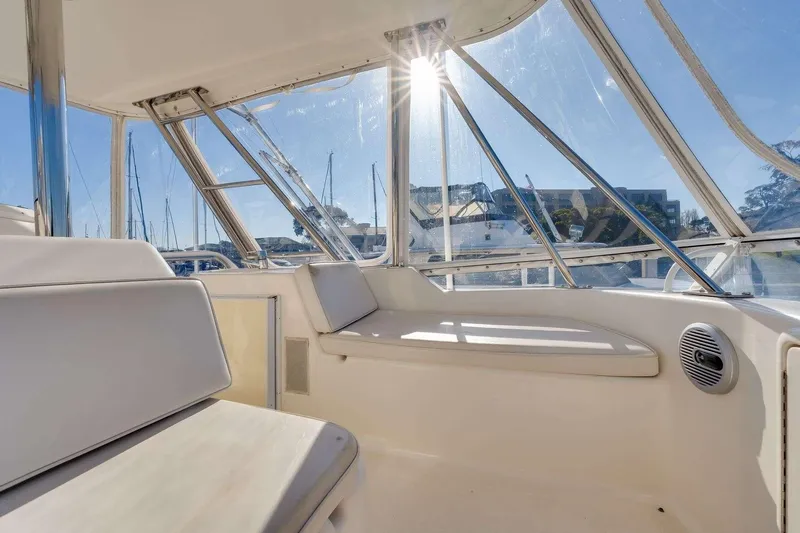 Slide: The Image of Interior of 2004 Riviera Convertible boat with sunlit seating and marina view. - 16