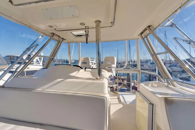Slide: The Image of 2004 Riviera Convertible yacht interior with marina view, featuring helm and seating area. - 17