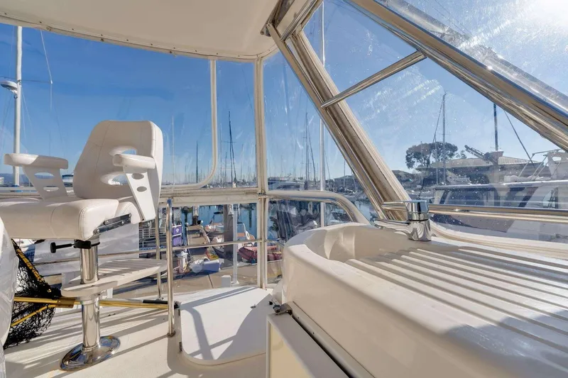 Slide: The Image of Interior view of 2004 Riviera Convertible yacht with white captain's chair and marina backdrop. - 18