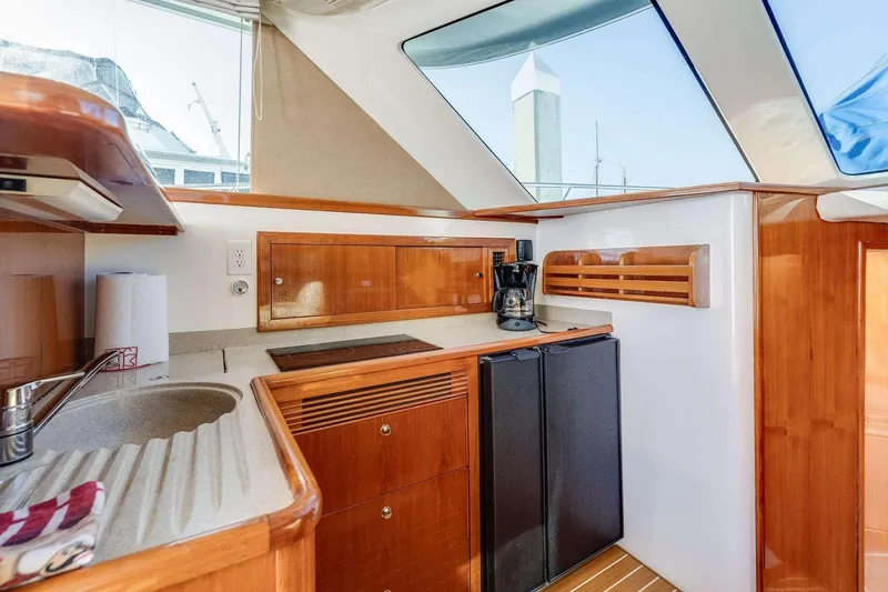 Slide: The Image of 2004 Riviera Convertible yacht kitchen with wooden cabinetry, sink, and appliances. - 25