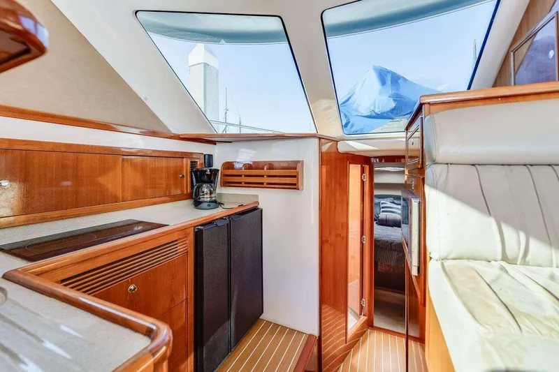 Slide: The Image of Luxurious interior of a 2004 Riviera Convertible yacht with wood finishes and skylights. - 26