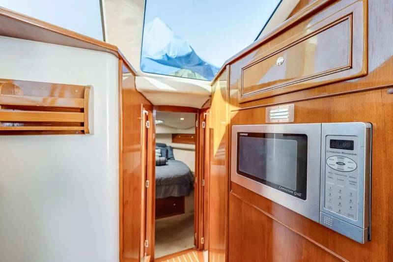 Slide: The Image of Interior of 2004 Riviera Convertible yacht with wood finish and built-in microwave. - 28