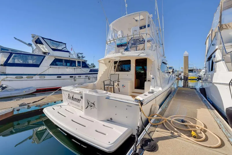 Slide: The Image of 2004 Riviera Convertible yacht docked at marina, showcasing sleek design and spacious deck. - 30