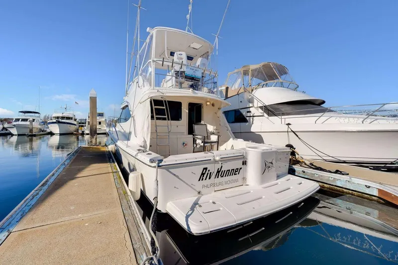 Slide: The Image of 2004 Riviera Convertible yacht docked at marina under clear blue sky. - 31