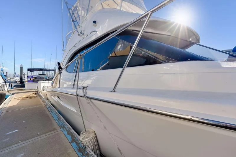 Slide: The Image of 2004 Riviera Convertible yacht docked under clear blue sky. - 32