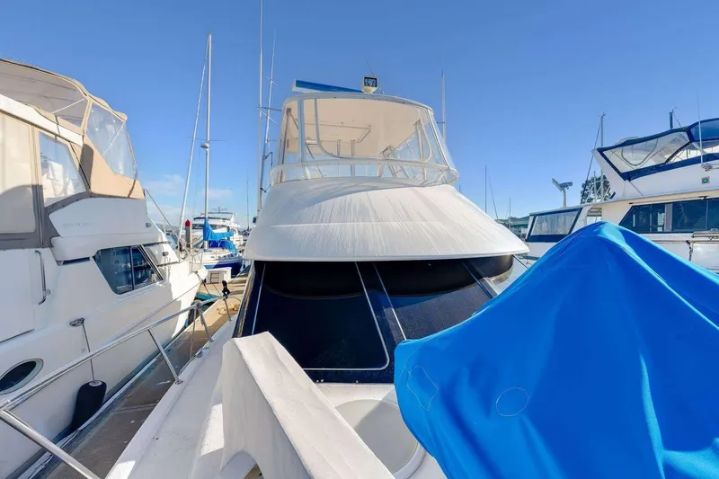 Slide: The Image of 2004 Riviera Convertible yacht docked among other boats under clear blue sky. - 34