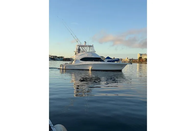 Slide: The Image of 2004 Riviera Convertible yacht on calm water at sunrise. - 37