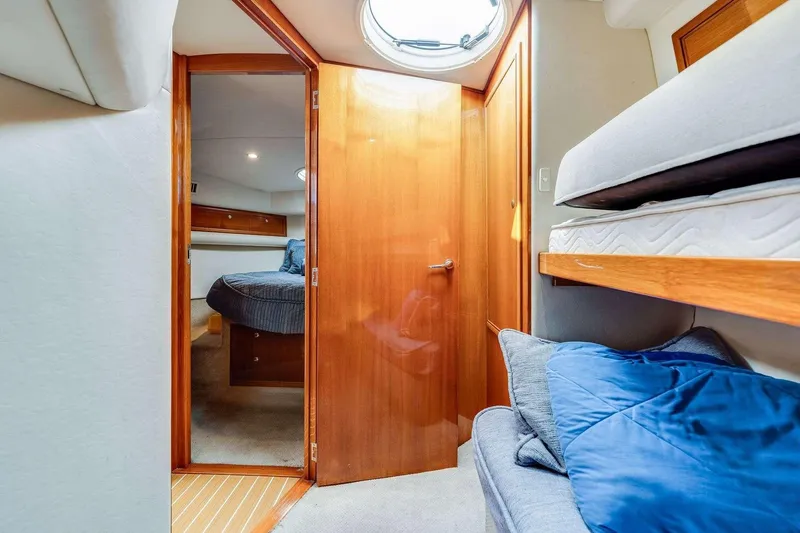 Slide: The Image of 2004 Riviera Convertible yacht interior with cozy cabin, wooden door, and bunk beds. - 7