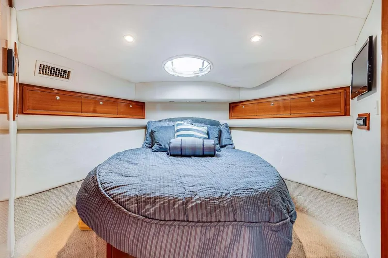 Slide: The Image of Luxurious 2004 Riviera Convertible yacht bedroom with cozy bedding and elegant wood cabinetry. - 8