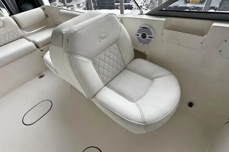 Slide: The Image of 2026 Key West 203 DFS boat interior with cushioned seating and speaker. - 14