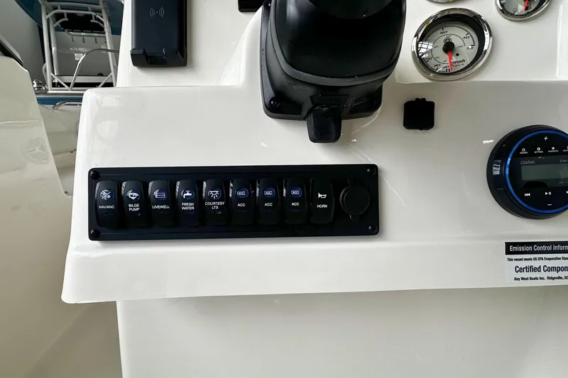 Slide: The Image of Control panel of 2026 Key West 203 DFS boat with switches and gauges. - 17