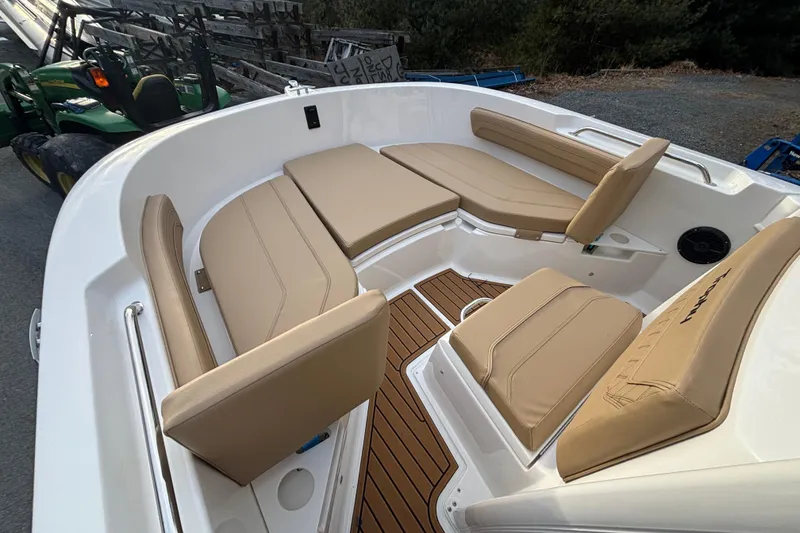 Slide: The Image of 2026 Bayliner Trophy T20CC boat interior with tan cushioned seating and wood-style flooring. - 13