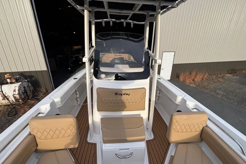 Slide: The Image of 2026 Bayliner Trophy T20CC boat interior with tan seating and wood-style flooring. - 14
