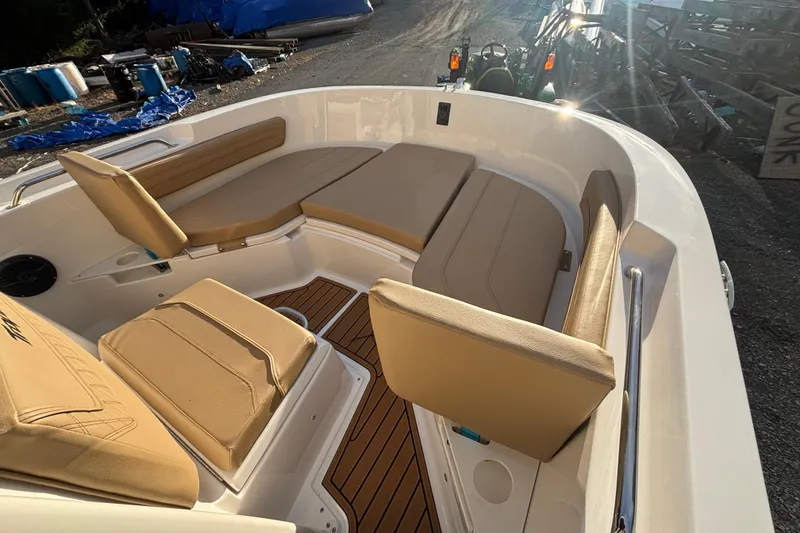 Slide: The Image of 2026 Bayliner Trophy T20CC boat interior with tan seating and wood accents. - 15