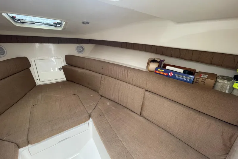 Slide: The Image of 2004 SeaVee 320i Cuddy interior with brown seating and storage space. - 22
