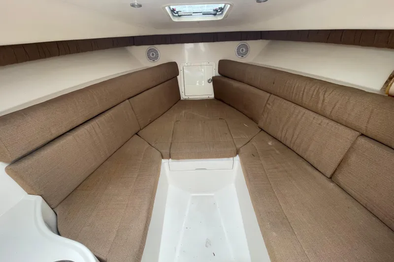 Slide: The Image of 2004 SeaVee 320i Cuddy interior with brown cushioned seating and white flooring. - 23