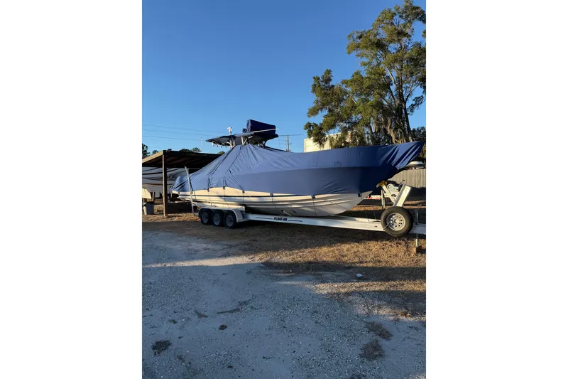 Slide: The Image of 2004 SeaVee 310i Cuddy boat on trailer, covered, parked outdoors. - 27