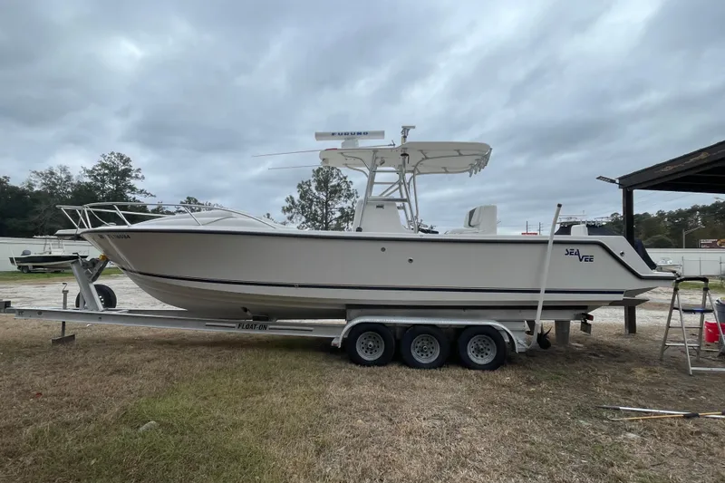 Slide: The Image of 2004 SeaVee 320i Cuddy boat on trailer, parked outdoors under cloudy sky. - 3
