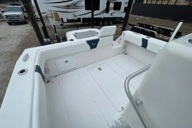 Slide: The Image of 2004 SeaVee 320i Cuddy boat deck with white seating and storage compartments. - 9