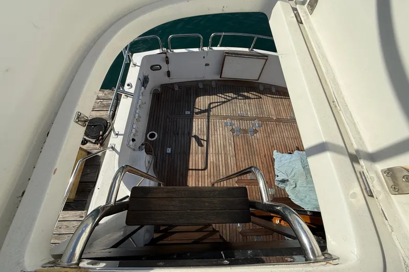 Slide: The Image of View of 1990 Mikelson 42 yacht deck with wooden flooring and metal railings. - 10