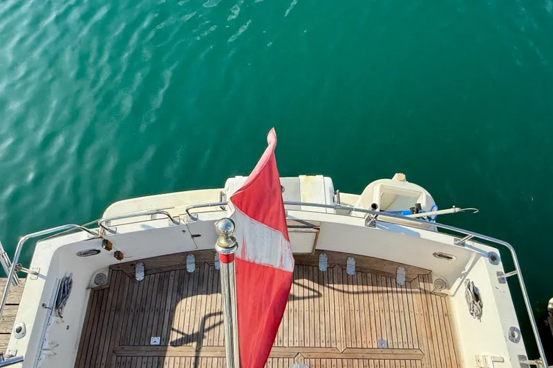 Slide: The Image of Aerial view of 1990 Mikelson 42 boat deck with red flag over turquoise water. - 11