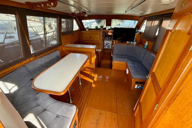 Slide: The Image of Interior of a 1990 Mikelson 42 yacht with wood paneling and seating area. - 15